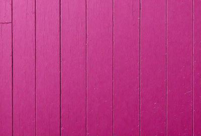The primary subject of the image is a pink wooden wall. The setting is a room with a pink wall, and the visual style is a close-up of the wall. The dominant colors are pink, and the overall atmosphere is warm and inviting.