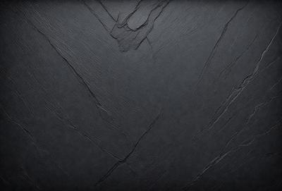The primary subject of the image is a black surface, possibly a piece of wood or a wall. The setting is a dark room, and the visual style appears to be a close-up of the black surface. The colors and mood of the image are predominantly dark and moody, with the black surface being the main focus.