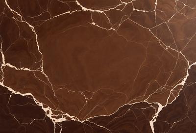 The image features a large, round, brown marble surface with a patterned texture. The primary subject is a marble table, which is the main focus of the image. The setting is a room with a brown marble wall, which serves as the backdrop for the table. The visual style is a close-up of the marble table, showcasing its unique texture and pattern. The colors and mood of the image are warm and earthy, with the brown marble creating a sense of luxury and sophistic