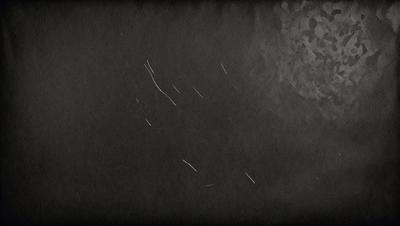 The primary subject of the image is a black background with a white line. The setting is a dark room, and the visual style is a black and white photo. The colors and mood of the image are predominantly dark and moody, with the white line being the only bright element in the scene.