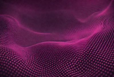 The primary subject of the image is a purple fabric with a pattern of dots. The setting is a close-up view of the fabric, showcasing its texture and pattern. The visual style is a digital art or illustration, as the dots are arranged in a visually appealing manner. The colors and mood of the image are predominantly purple, creating a calm and soothing atmosphere.