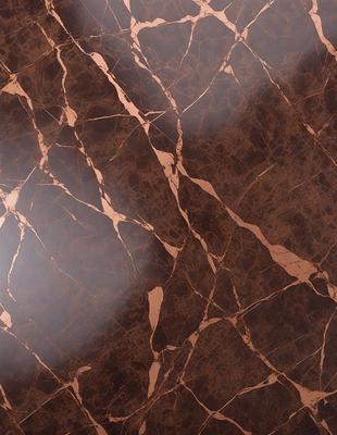 The primary subject of the image is a marble surface with a brown and white pattern. The setting is a room with a brown and white marble wall, which adds to the overall atmosphere. The visual style is a close-up of the marble surface, showcasing its intricate pattern. The colors and mood of the image are warm and elegant, with the brown and white marble creating a sophisticated and luxurious ambiance.