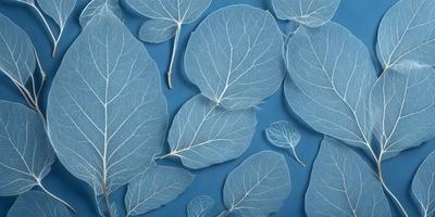 The primary subject of the image is a collection of leaves, which are displayed on a blue surface. The leaves are arranged in various positions, creating a visually appealing and artistic display. The setting appears to be a studio or a workspace, where the artist has created this unique arrangement of leaves. The visual style of the image is a combination of photo and digital art, as it captures the intricate details of the leaves while maintaining a creative and artistic touch. The colors and mood of the image are predomin
