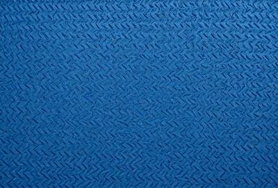 The primary subject of the image is a blue, woven fabric with a pattern of interlocking diamonds. The setting is a blue background, which complements the blue fabric. The visual style is a close-up of the fabric, showcasing its intricate design. The colors and mood of the image are predominantly blue, creating a calm and serene atmosphere.
