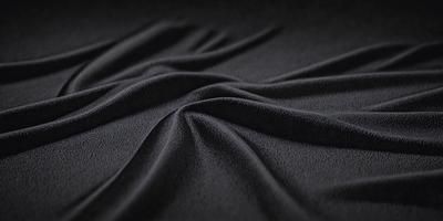 The primary subject of the image is a black fabric, which appears to be a piece of cloth or a curtain. The setting is a dark background, which contrasts with the black fabric. The visual style is a close-up of the fabric, showcasing its texture and details. The colors and mood of the image are predominantly dark, with the black fabric being the main focus.