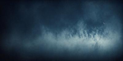 The primary subject of the image is a cloudy sky. The setting is a dark, cloudy day with a blue sky. The visual style is a photo, capturing the beauty of the cloudy sky. The colors and mood of the image are dark and moody, with the blue sky contrasting against the cloudy backdrop.