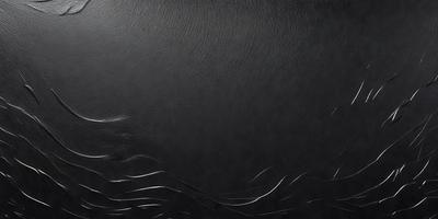 The primary subject of the image is a black leather surface, which appears to be a leather jacket. The setting is a dark room, and the visual style is a close-up of the leather surface. The colors and mood of the image are predominantly dark and moody, with the black leather creating a striking contrast against the dark background.