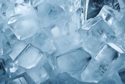 The primary subject of the image is a large pile of ice cubes. The setting is a dark background, which contrasts with the bright white color of the ice cubes. The visual style is a close-up of the ice cubes, showcasing their texture and details. The colors and mood of the image are predominantly white, giving it a clean and cold appearance.