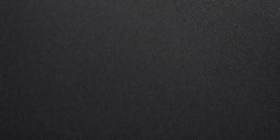 The primary subject of the image is a black leather surface. The setting is a dark room, and the visual style is a close-up of the leather surface. The colors and mood of the image are predominantly dark and moody, with the black leather surface being the main focus.