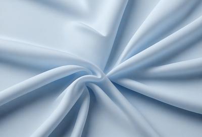 The primary subject of the image is a white sheet of fabric. The setting is a white background, which creates a clean and minimalist appearance. The visual style is a close-up of the fabric, showcasing its texture and details. The colors and mood of the image are predominantly white, giving it a calm and serene atmosphere.