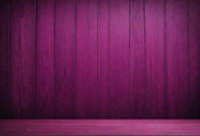 The primary subject of the image is a wooden wall with a purple color. The setting is a room with a wooden floor. The visual style is a photo, and the dominant colors are purple and brown. The overall atmosphere is warm and inviting.