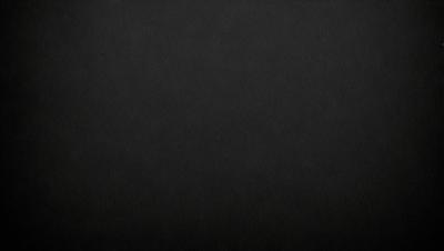 The primary subject of the image is a black background. The setting is a dark room, and the visual style is a black and white photo. The colors and mood of the image are predominantly dark and moody.