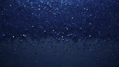 The primary subject of the image is a blue background with a pattern of white stars. The setting appears to be a dark background, possibly a night sky. The visual style of the image is a close-up of the blue background with the white stars, creating a sense of depth and detail. The colors and mood of the image are predominantly dark and moody, with the blue background and white stars creating a sense of calmness and tranquility.