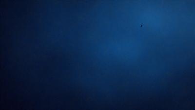 The primary subject of the image is the night sky, which is filled with a few stars. The setting is a dark, cloudy night, with the sky being the main focus of the image. The visual style is a photo, capturing the beauty of the night sky. The colors and mood of the image are dark and moody, with the stars being the only source of light in the scene.