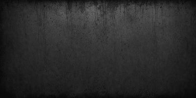 The primary subject of the image is a black and white photo of a wall. The setting is a dark room with a wall that appears to be dirty or stained. The visual style is a black and white photo, which gives the image a classic and timeless appearance. The colors and mood of the image are predominantly dark and moody, with the black and white tones adding to the overall atmosphere.