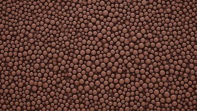 The primary subject of the image is a close-up of a brown surface, which appears to be a wall or a piece of fabric. The setting is indoors, and the visual style is a close-up of a patterned surface. The colors and mood of the image are predominantly brown, giving it a warm and earthy atmosphere.