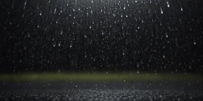 The primary subject of the image is a rainy night scene with a focus on the rain falling on the ground. The setting is a dark, rainy night with a backdrop of a dark sky. The visual style is a photo, capturing the raindrops on the ground. The colors and mood of the image are dominated by the darkness and the sound of the rain, creating a moody and atmospheric scene.