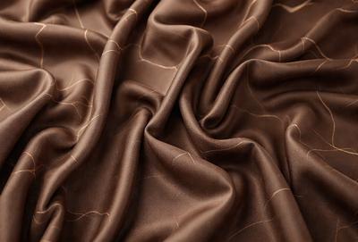 The primary subject of the image is a brown fabric, possibly a piece of cloth or a curtain. The setting is a room with a brown background, which adds to the overall atmosphere. The visual style is a close-up of the fabric, showcasing its texture and details. The colors and mood of the image are predominantly brown, giving it a warm and cozy feel.