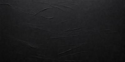 The primary subject of the image is a black background with a pattern of wrinkles and folds. The setting is a dark room, and the visual style appears to be a close-up of the wrinkled surface. The colors and mood of the image are predominantly dark and moody, with the black background and wrinkles creating a sense of depth and texture.