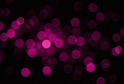 The primary subject of the image is a purple light, which appears to be a light source or a purple neon sign. The setting is a dark background, which contrasts with the purple light. The visual style of the image is a close-up of the purple light, emphasizing its color and texture. The colors and mood of the image are predominantly purple, creating a moody and atmospheric scene.