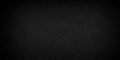 The primary subject of the image is a black background. The setting is a dark room, and the visual style is a black and white photo. The colors and mood of the image are dark and moody, creating a sense of mystery or drama.