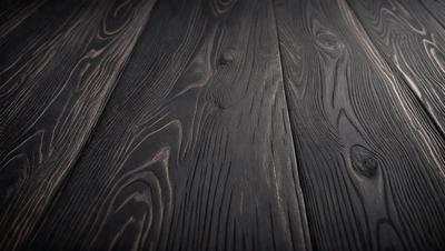 The primary subject of the image is a wooden floor. The setting is a room with a wooden floor, and the visual style is a photo. The colors and mood of the image are dark and moody, with the wooden floor being the main focus.