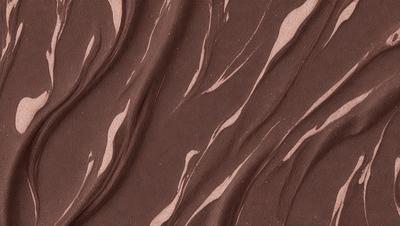 The primary subject of the image is a brown and white patterned surface, which appears to be a piece of fabric or a wallpaper design. The setting is a room with a brown and white color scheme. The visual style is a combination of a photo and a patterned design, creating a unique and eye-catching appearance. The colors and mood of the image are warm and inviting, with the brown and white colors evoking a sense of comfort and familiarity.