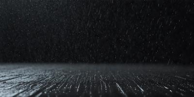 The primary subject of the image is a rainy night scene with a dark background. The setting is a wet street, and the visual style is a black and white photo. The colors and mood of the image are predominantly dark and moody, with the rain creating a sense of atmosphere.
