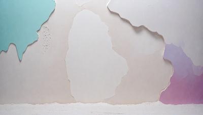 The primary subject of the image is a white wall with a few holes in it. The setting is a room with a white wall, and the visual style appears to be a photo. The dominant colors are white and beige, creating a clean and neutral atmosphere.