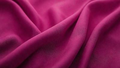 The primary subject of the image is a piece of pink fabric. The setting is a room with a pink background. The visual style is a close-up of the fabric, showcasing its texture and color. The colors and mood of the image are predominantly pink, creating a warm and inviting atmosphere.