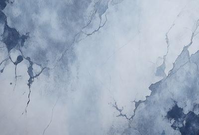 The primary subject of the image is a blue and white wall with a cracked and chipped appearance. The setting is a room with a blue and white color scheme. The visual style is a close-up of the wall, showcasing its texture and details. The colors and mood of the image are predominantly blue and white, giving it a calm and serene atmosphere.