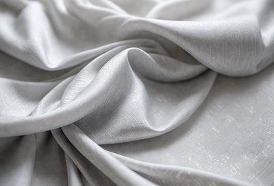 The primary subject of the image is a piece of fabric, which is the main object, scene, or focus of the image. The setting or background is a white surface, and the visual style is a photo. The colors and mood of the image are predominantly gray, giving it a calm and serene atmosphere.