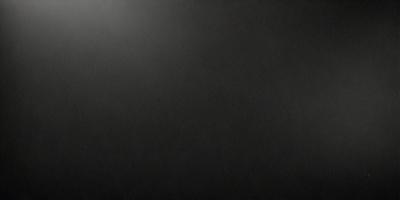 The primary subject of the image is a black background. The setting is a dark room, and the visual style is a black and white photo. The colors and mood of the image are dark and moody, creating a sense of mystery or drama.