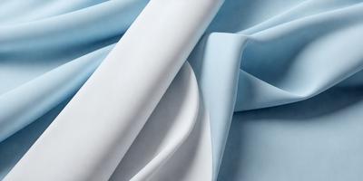 The primary subject of the image is a white sheet of fabric. The setting is a blue background, which creates a contrasting and visually appealing scene. The visual style is a close-up of the fabric, showcasing its texture and details. The colors and mood of the image are predominantly white and blue, giving it a clean and serene atmosphere.