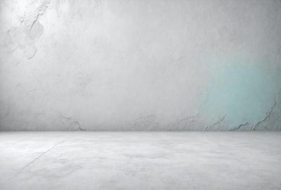 The primary subject of the image is a large, white wall. The setting is a plain, empty room with a cement floor. The visual style is a photo, and the colors and mood are predominantly white, giving the scene a clean and minimalist appearance.