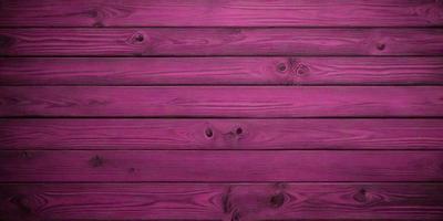 The primary subject of the image is a wooden wall with a purple color. The setting is a room with a wooden surface, and the visual style is a close-up of the wooden wall. The dominant colors are purple and brown, creating a warm and cozy atmosphere.