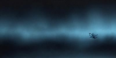 The primary subject of the image is a blue background with a few white streaks. The setting appears to be a dark room, possibly a night sky. The visual style is a black and white photo, giving it a classic and timeless appearance. The colors and mood of the image are predominantly dark and moody, with the blue background providing a sense of depth and contrast.