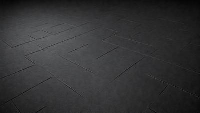 The primary subject of the image is a black carpeted floor. The setting is a dark room, and the visual style is a close-up of the carpet. The colors and mood of the image are predominantly dark, with the black carpet being the main focus.