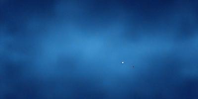 The primary subject of the image is a blue sky with a few stars visible. The setting is a vast, open space with no visible landmarks or objects. The visual style is a natural, outdoor scene with a focus on the sky and the stars. The colors and mood are predominantly blue and serene, creating a peaceful and tranquil atmosphere.