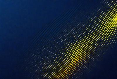The primary subject of the image is a blue background with a pattern of yellow dots. The setting appears to be a dark room, and the visual style is a combination of a photo and digital art. The dominant colors are blue and yellow, creating a mood of calmness and tranquility.