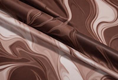 The primary subject of the image is a brown and white fabric, which is the main object, scene, or focus of the image. The setting or background is a white surface, and the visual style appears to be a photo. The colors and mood of the image are predominantly brown and white, giving it a classic and elegant appearance.