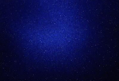 The primary subject of the image is the night sky, which is filled with stars. The setting is a dark, star-filled sky, and the visual style is a photo. The colors and mood of the image are predominantly dark and serene, with the stars providing a sense of depth and beauty.