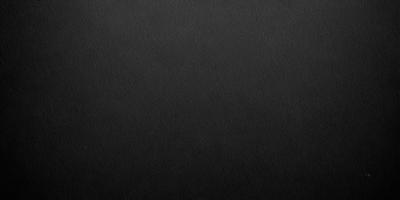 The primary subject of the image is a black background. The setting is a dark room, and the visual style is a black and white photo. The colors and mood of the image are dark and moody, creating a sense of mystery or drama.