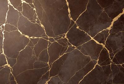 The primary subject of the image is a marble wall with a gold-like pattern. The setting is a room with a brown background. The visual style is a close-up of the marble wall, showcasing its intricate design. The colors and mood of the image are warm and elegant, with the gold pattern adding a touch of luxury to the marble wall.