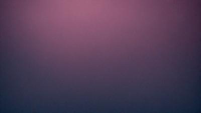 The primary subject of the image is a purple wall. The setting is a dark room, and the visual style appears to be a photo. The dominant colors are purple and dark, creating a moody atmosphere.