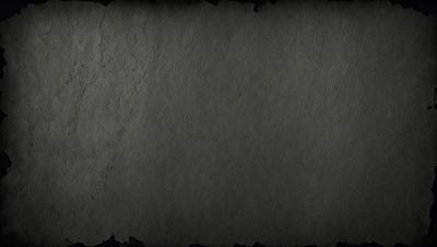 The primary subject of the image is a large, gray, textured surface. The setting is a dark, possibly industrial, environment. The visual style is a close-up of the gray surface, which appears to be a piece of concrete or a similar material. The colors and mood of the image are predominantly dark and moody, with the gray surface being the main focus.
