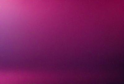 The primary subject of the image is a pink background. The setting is a dark, purple-pink room. The visual style is a close-up of the pink background, which creates a moody and dramatic atmosphere.