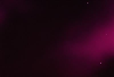 The primary subject of the image is a purple background. The setting is a dark, cloudy sky, which creates a moody atmosphere. The visual style is a photo, capturing the purple hue and the cloudy sky. The colors and mood of the image are predominantly purple, with a hint of darkness, giving it a somewhat mysterious and dramatic appearance.