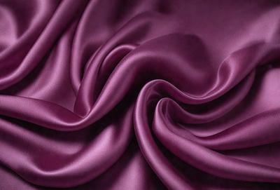 Purple fabric with a pattern of swirls and curls.