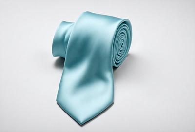 The primary subject of the image is a blue tie. The tie is placed on a white background, which creates a clean and minimalist appearance. The visual style of the image is a close-up of the tie, emphasizing its color and texture. The dominant colors in the image are blue and white, giving the scene a calm and professional atmosphere.
